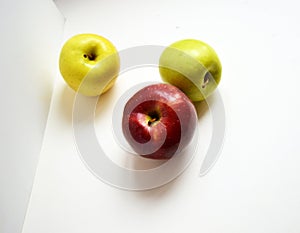 Top view of fruits. Three fresh and shiny green, red and yellow apples on a white background ÃÂ 